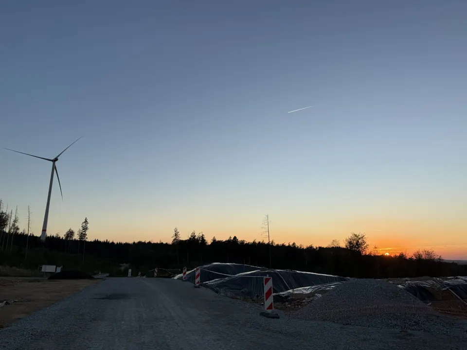 Windrad und Baustelle bei Sonnenuntergang