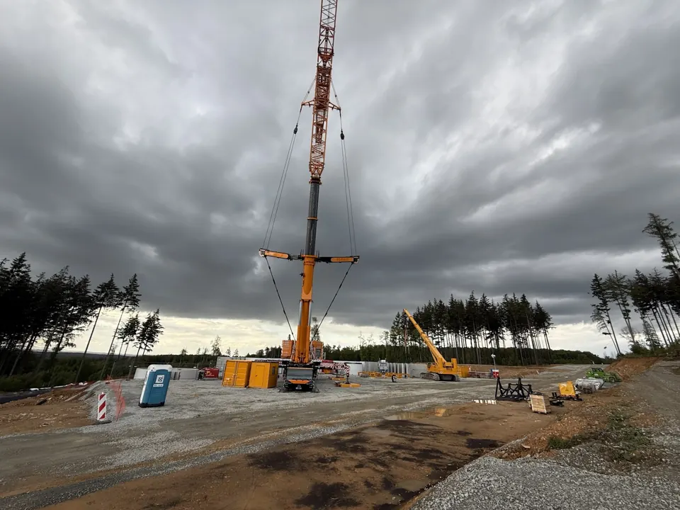 Hoher Kran auf der Baustelle unter dunklen Wolken