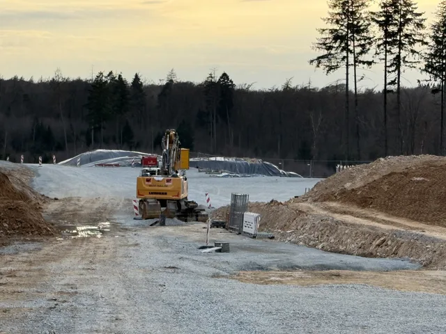 Bagger zwischen Erdhaufen im warmen Abendlicht